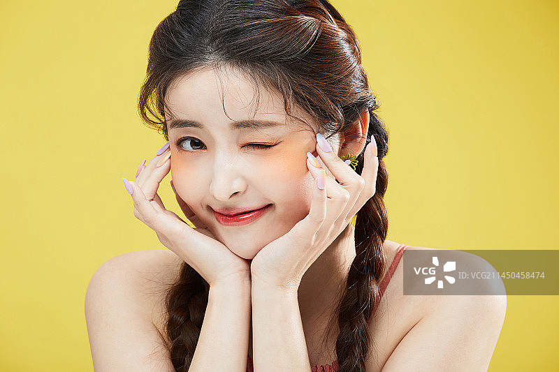 韩国亚洲美丽女性单手托腮，俏皮眨眼美妆概念摄影图片素材