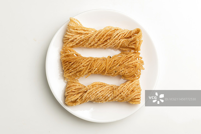 特色小吃一盘油炸馓子摆放在桌面上特写图片素材