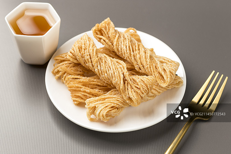 特色小吃一盘油炸馓子摆放在桌面上特写图片素材