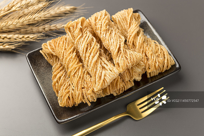 特色小吃一盘油炸馓子摆放在桌面上特写图片素材