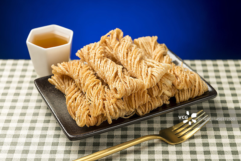 特色小吃一盘油炸馓子摆放在桌面上特写图片素材