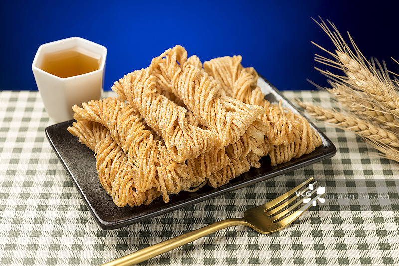 特色小吃一盘油炸馓子摆放在桌面上特写图片素材