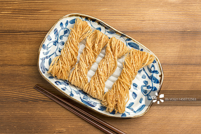 特色小吃一盘油炸馓子摆放在桌面上特写图片素材