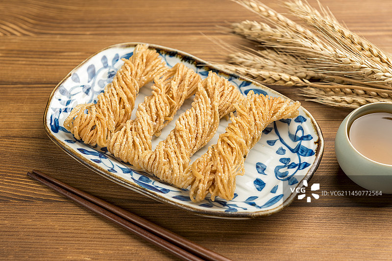 特色小吃一盘油炸馓子摆放在桌面上特写图片素材