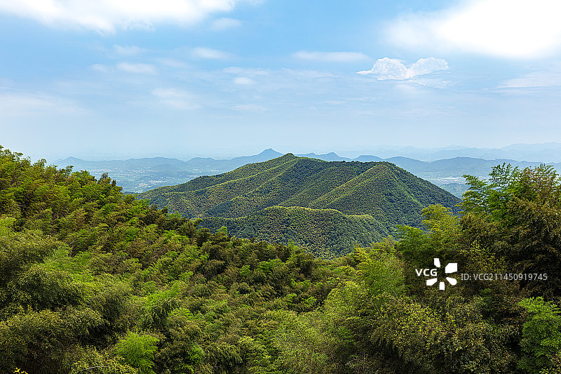 浙江杭州余杭径山寺眺望远方，蓝天白云下，山峰迭起，竹林翠绿茂密图片素材