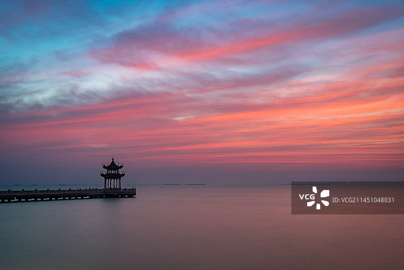 无锡拈花湾附近的太湖之滨十里明珠堤的日出朝霞红霞满天，中式凉亭和栈桥向太湖延伸，太湖水面平静如梦似幻图片素材