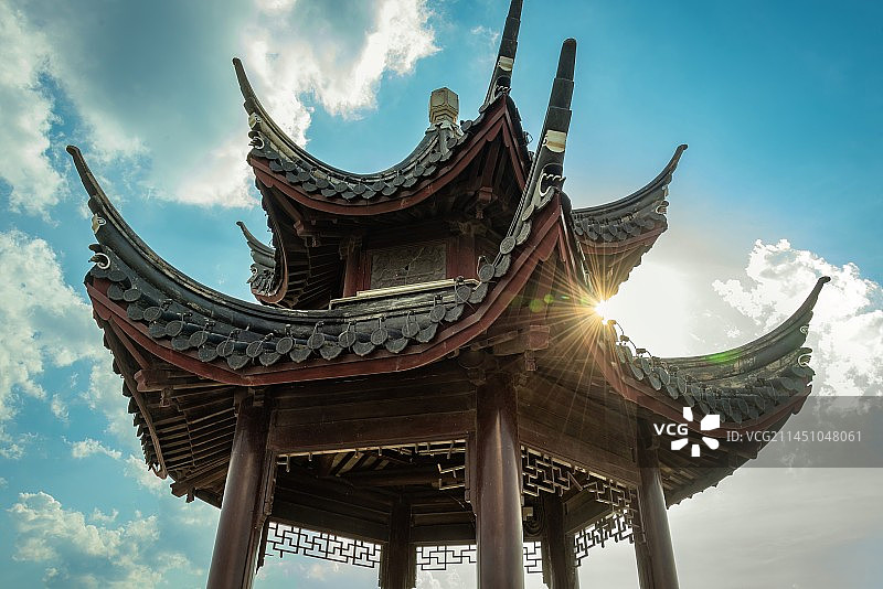 蓝天白云下无锡宜兴太湖边的丁蜀镇太湖绿道向太湖水面延伸，路的尽头古色古香的六角凉亭，温暖太阳射出光芒图片素材