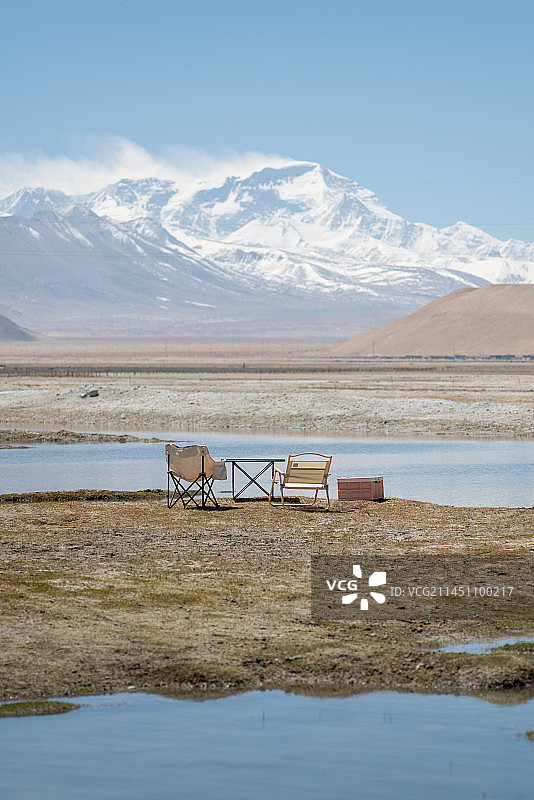 坐在雪山下的湖泊边露营图片素材