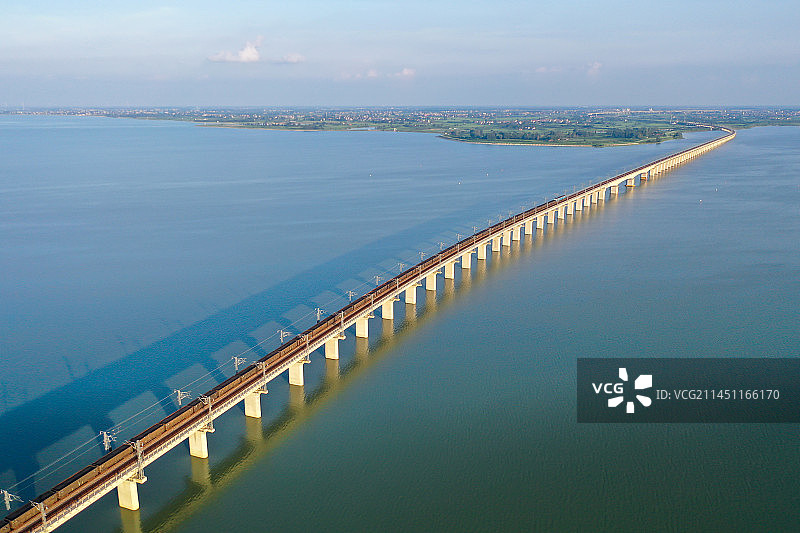 夕照中一列货运列车经过长湖大桥图片素材