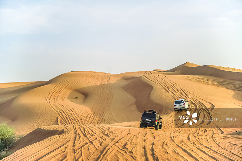 夏季阿联酋迪拜旅游景点沙漠冲沙行程中行驶的车辆图片素材
