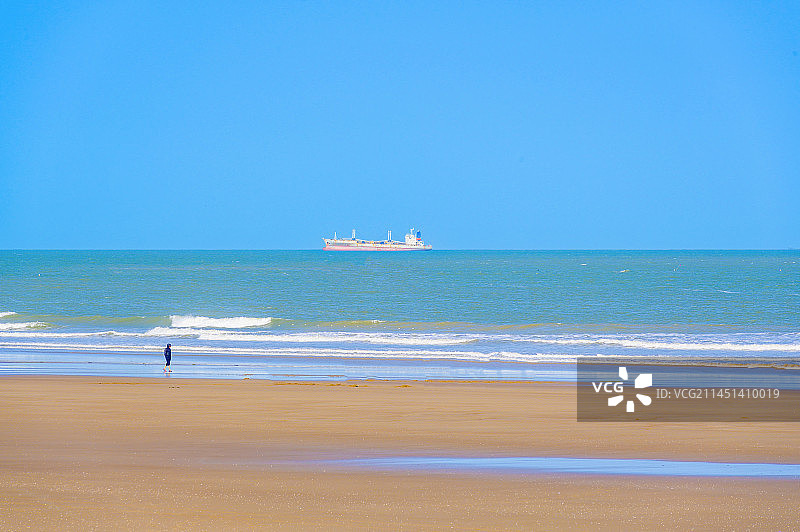 福建平潭沙滩上行走的人和蓝色大海上的轮船图片素材