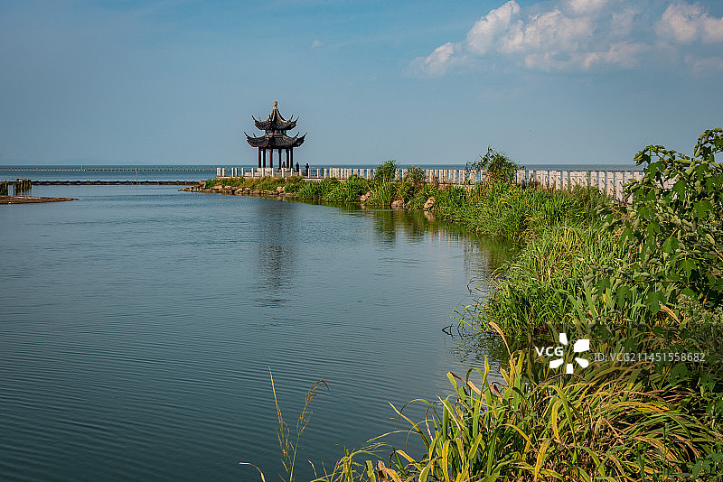 蓝天白云下无锡宜兴太湖边的丁蜀镇太湖绿道向太湖水面延伸，路的尽头是一座古色古香的六角凉亭图片素材