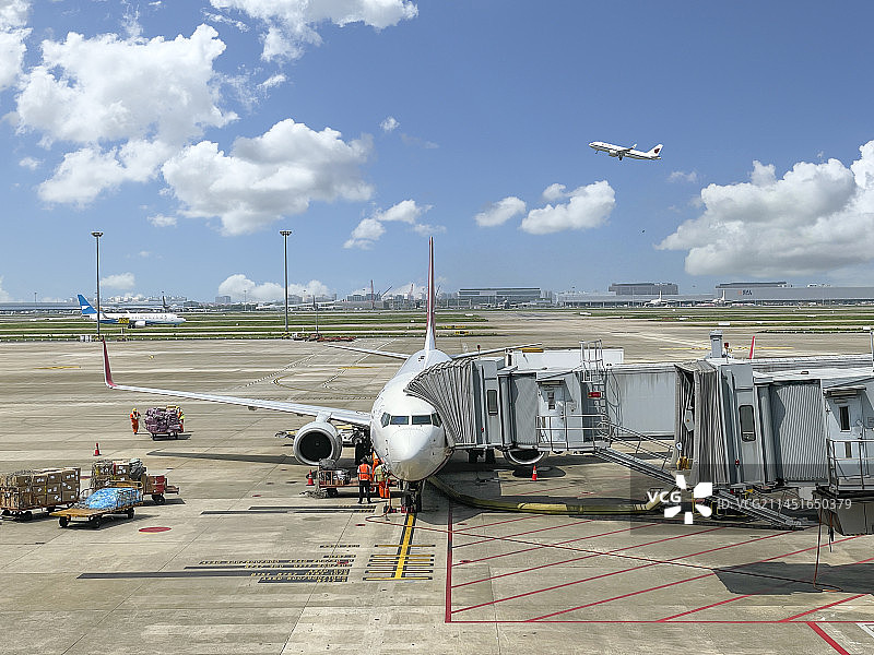 上海浦东国际机场S1航站楼停机坪廊桥旁乘客准备登机起飞的客机图片素材