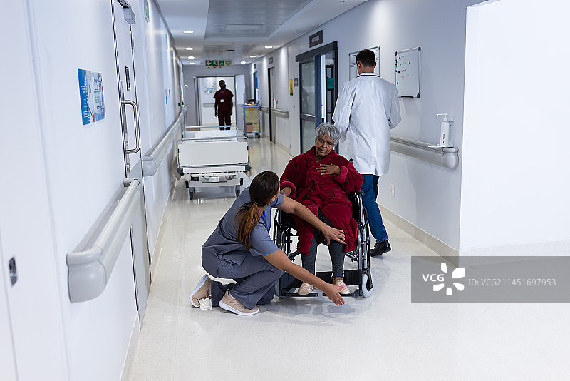 亚洲女医生在医院走廊检查坐轮椅的多样化老年女患者的腿部图片素材