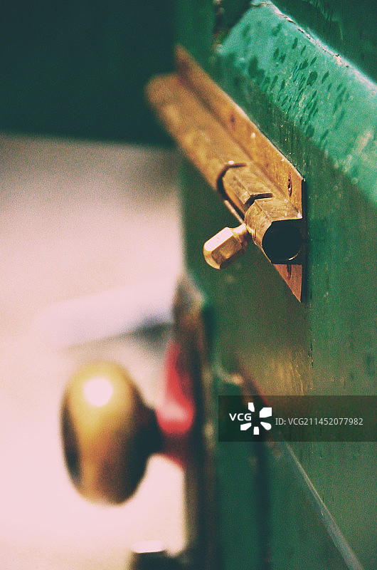 中国传统房屋建筑拍摄主题，古老的绿色的房屋房门，木门上金黄色的插销，户外白昼无人图像摄影图片素材