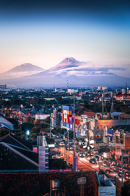 印尼日惹黄昏时分的城市与火山背景图片素材