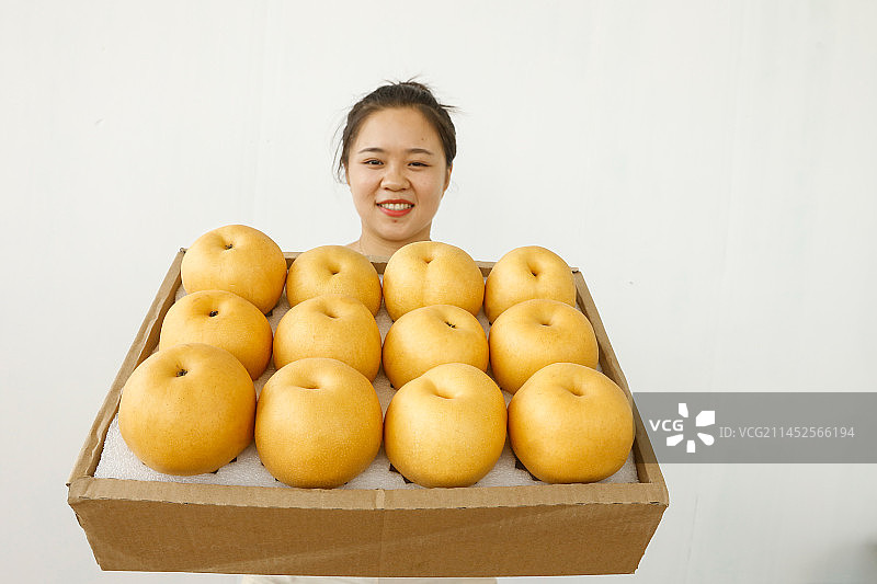 手里拿着一箱秋月梨图片素材