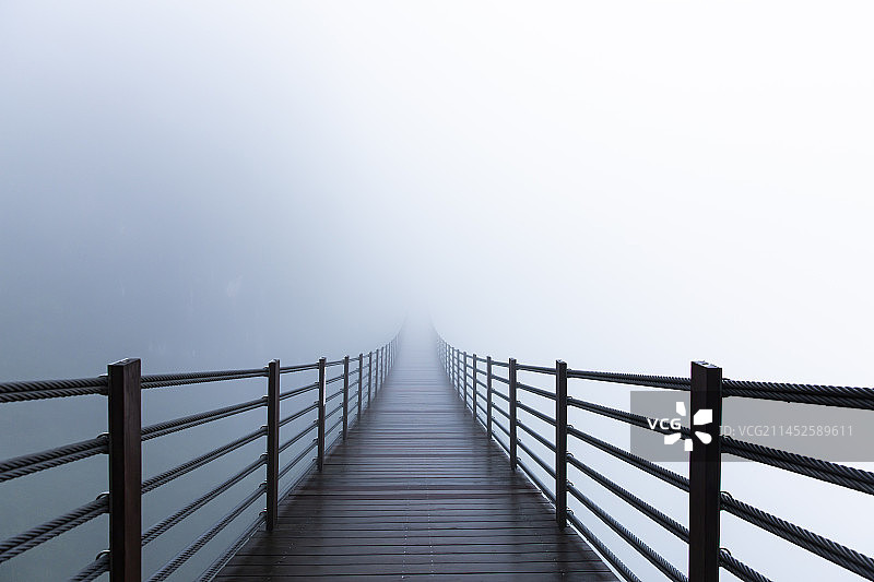 重庆武陵山大裂谷云雾中的迷雾索道桥图片素材