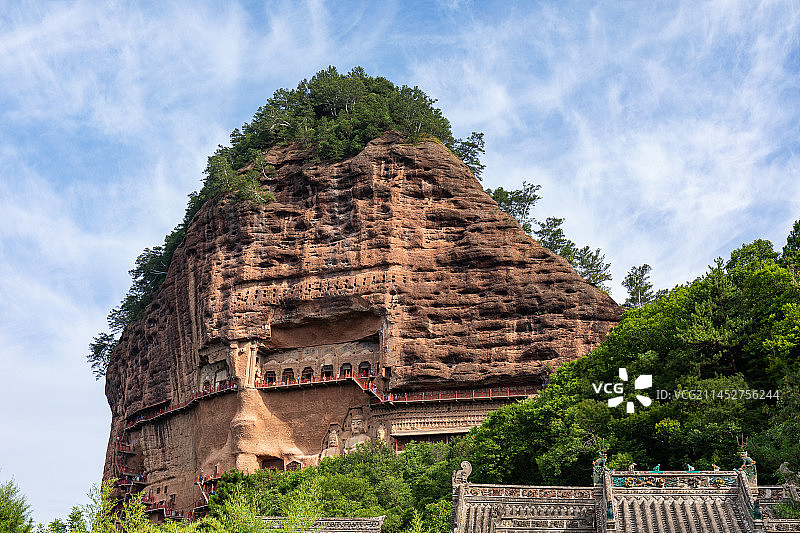 甘肃天水麦积山石窟建在石头山上的佛教造像窟夏天覆盖着绿色树木的麦积山全貌图片素材