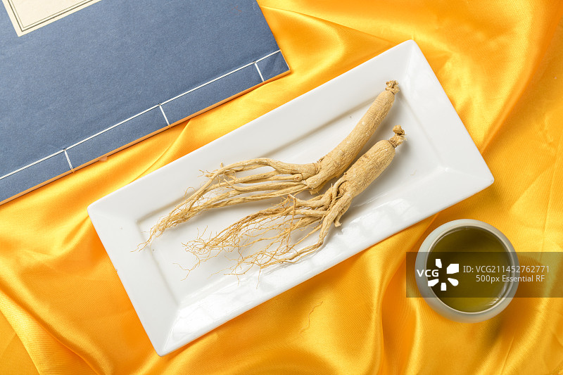 名贵滋补中药材整根人参摆放黄绸缎背景特写图片素材