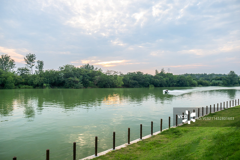 夏末初秋灿烂晚霞下的扬州生态科技新城七河八岛太平河上飞驰的摩托挺图片素材