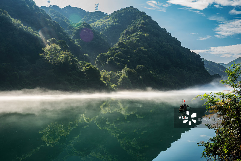 雾漫小东江-渔民在晨雾中划船撒网捕鱼图片素材
