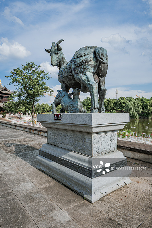蓝天白云下浙江省绍兴市上虞区曹娥江风景区中华孝德园中的羊羔跪乳青铜像图片素材