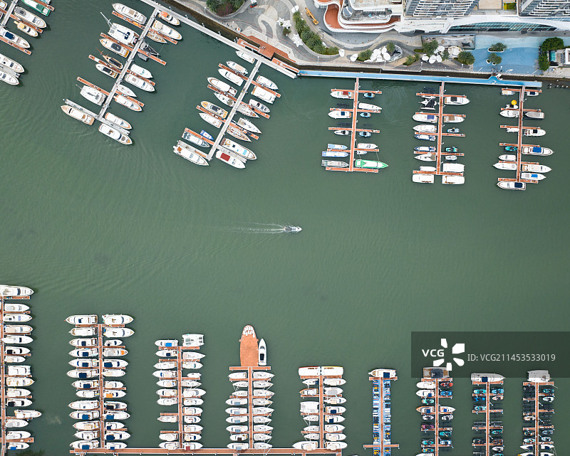 河道两边停靠着游艇，中间是行使的渔船图片素材
