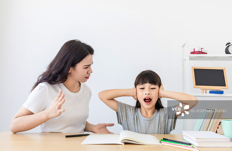 一名中国妈妈在辅导女儿写作业图片素材