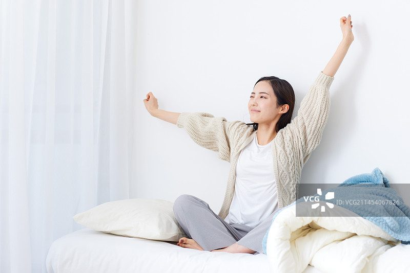 坐在床上的年轻日本女人图片素材