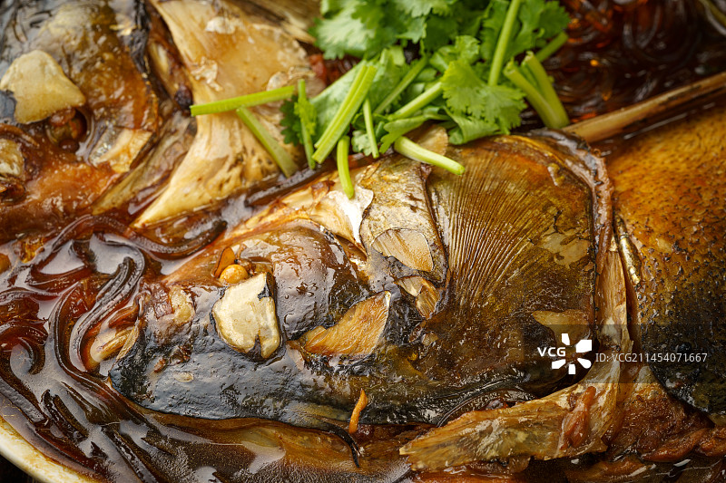 木质背景下的东北特色美食粉条炖鱼头图片素材