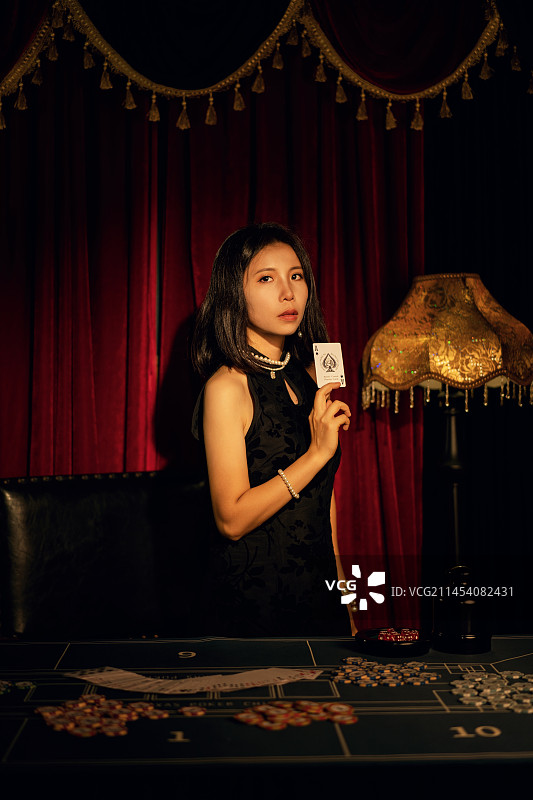 中国中式传统穿着旗袍发牌的女子图片素材