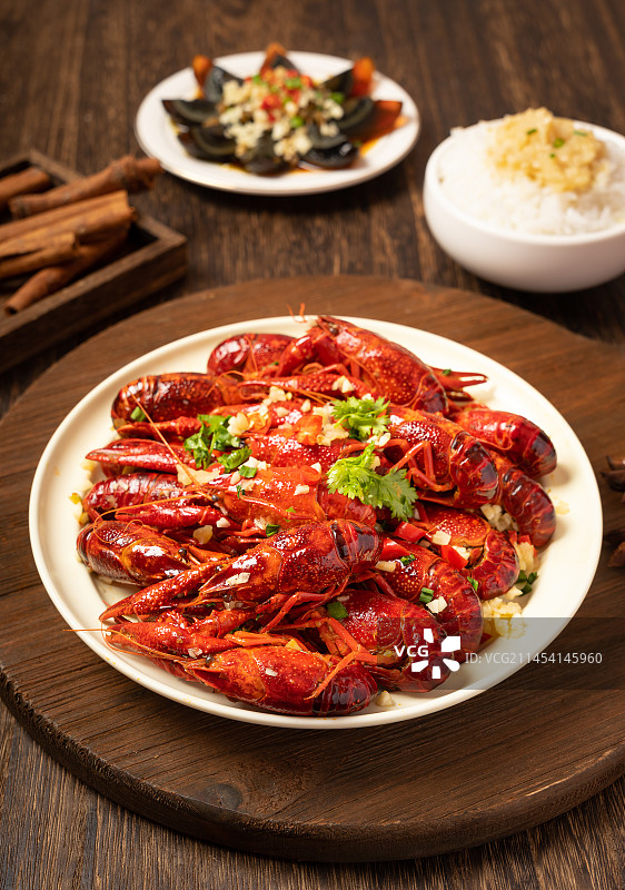 深色木板上盘子里的小龙虾图片素材