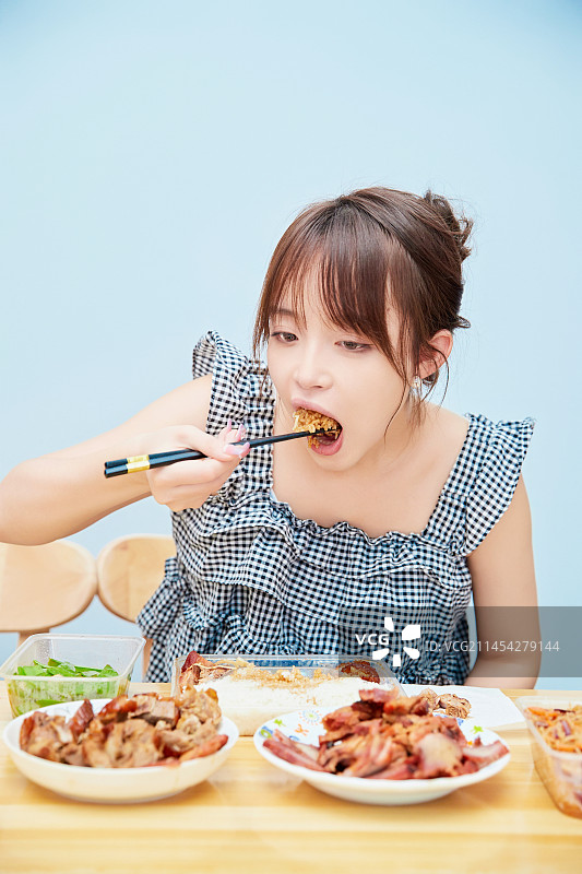 在餐桌前吃午餐的亚洲少女图片素材