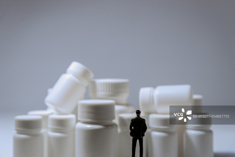 堆叠的药瓶和人偶：医疗 医药 医保 医药反腐 医疗反腐图片素材