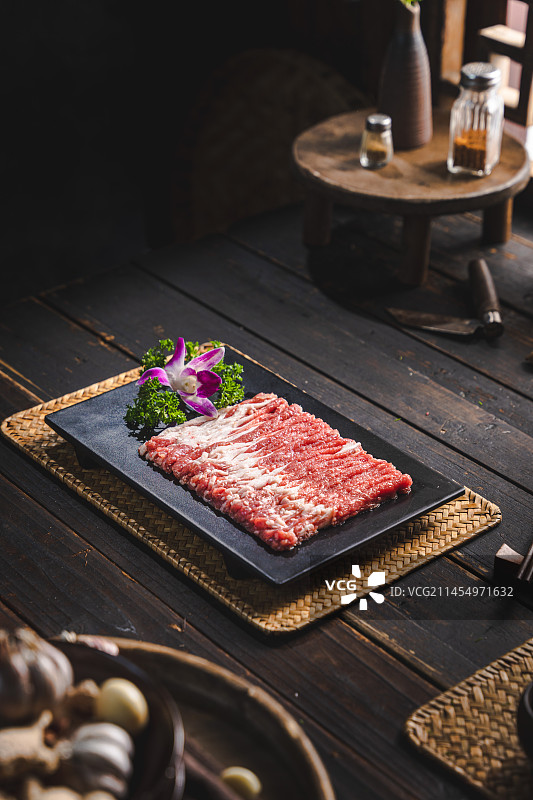 复古农家窗边餐桌上的老北京铜锅鲜切羊肉图片素材