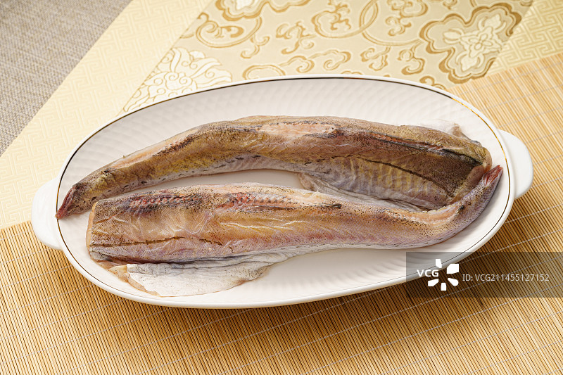 放在白瓷盘内的新鲜明太鱼图片素材