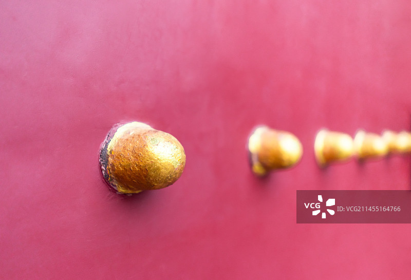 中国古代建筑城门大门拍摄主题。红色木质大门和成一排的黄的门钉，户外白昼无人图像静物摄影图片素材