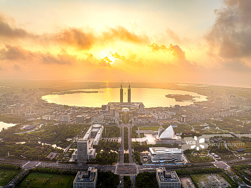 临港新城日出 滴水湖中银大厦 东海之滨 上海浦东临港自贸区 红色朝阳穿过云层照耀城市图片素材