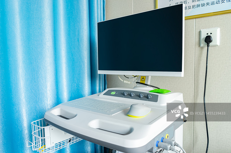 中国医疗器械拍摄主题，一位医生坐在一台用于给病人检查身体的医疗仪器前操作设备用品，室内图像摄影图片素材