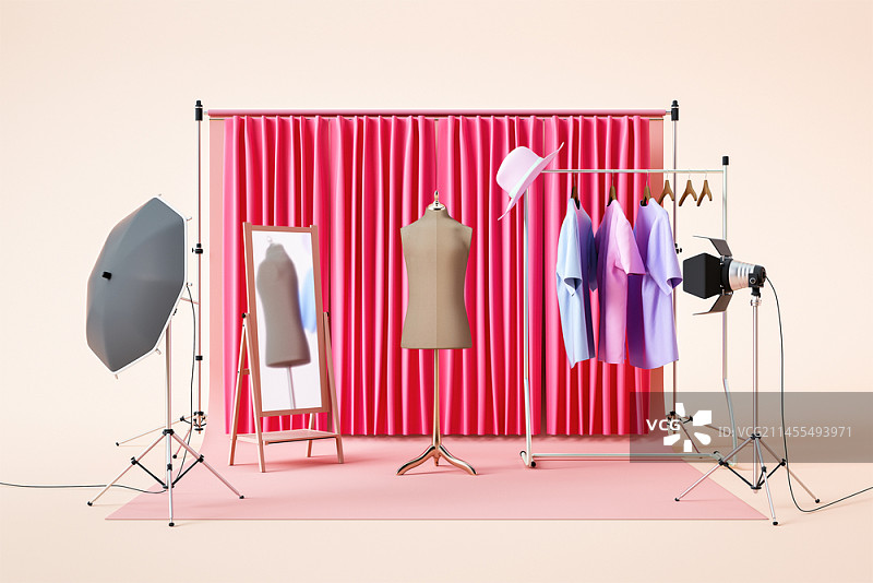 工作室里穿着挂在衣架上的衣服的模特图片素材