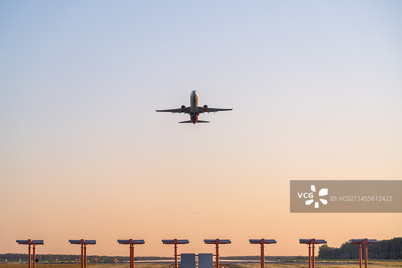 飞机在机场跑道前起飞降落逆光美景图片素材