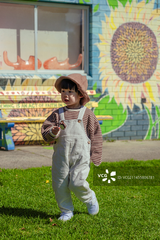 国外涂鸦创意街上吃棒棒糖的牛仔小男孩图片素材