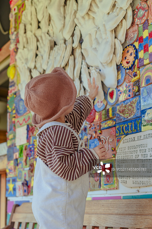 国外涂鸦创意街上吃棒棒糖的牛仔小男孩图片素材