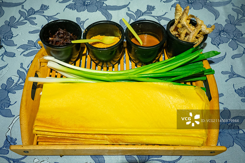 中国餐饮行业饮食产业，传统经典中国食品，美食拍摄主题，一盘子山东煎饼卷大葱美食特写，室内无人图像图片素材