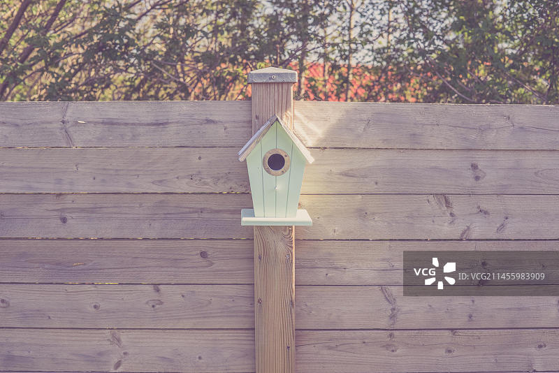 花园木栅栏上的可爱鸟舍图片素材