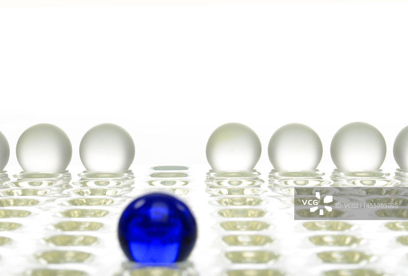 蓝色球体与一排白色球体，象征与众不同图片素材