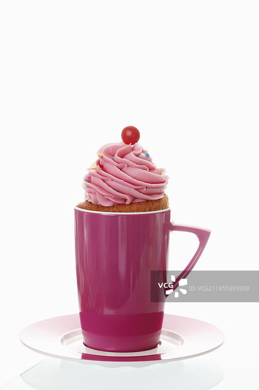 粉色咖啡杯中的草莓奶油纸杯蛋糕图片素材