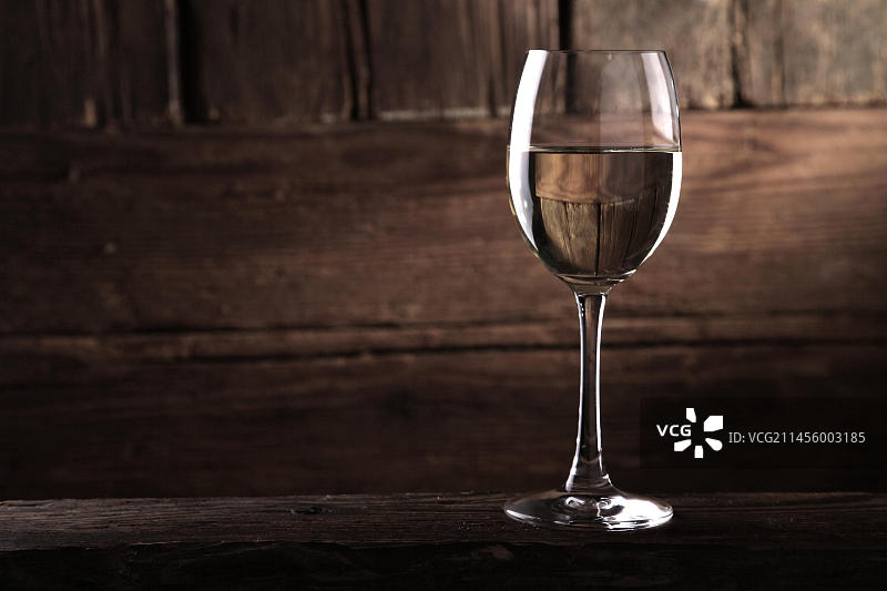 在质朴的木墙前喝一杯白葡萄酒图片素材