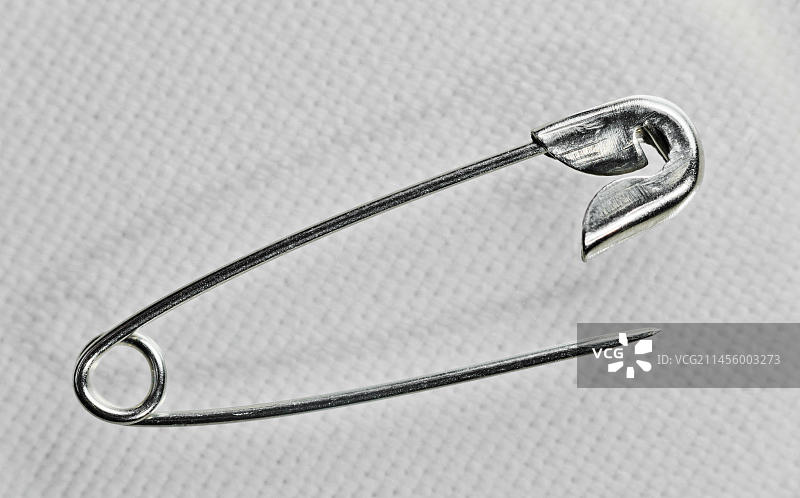 白色亚麻布上的安全别针图片素材